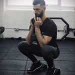 Man in a gym performing a goblet squat on the forte fitness slant blocks
