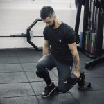 Man in a gym performing dumbbell split squats using he forte fitness slant blocks