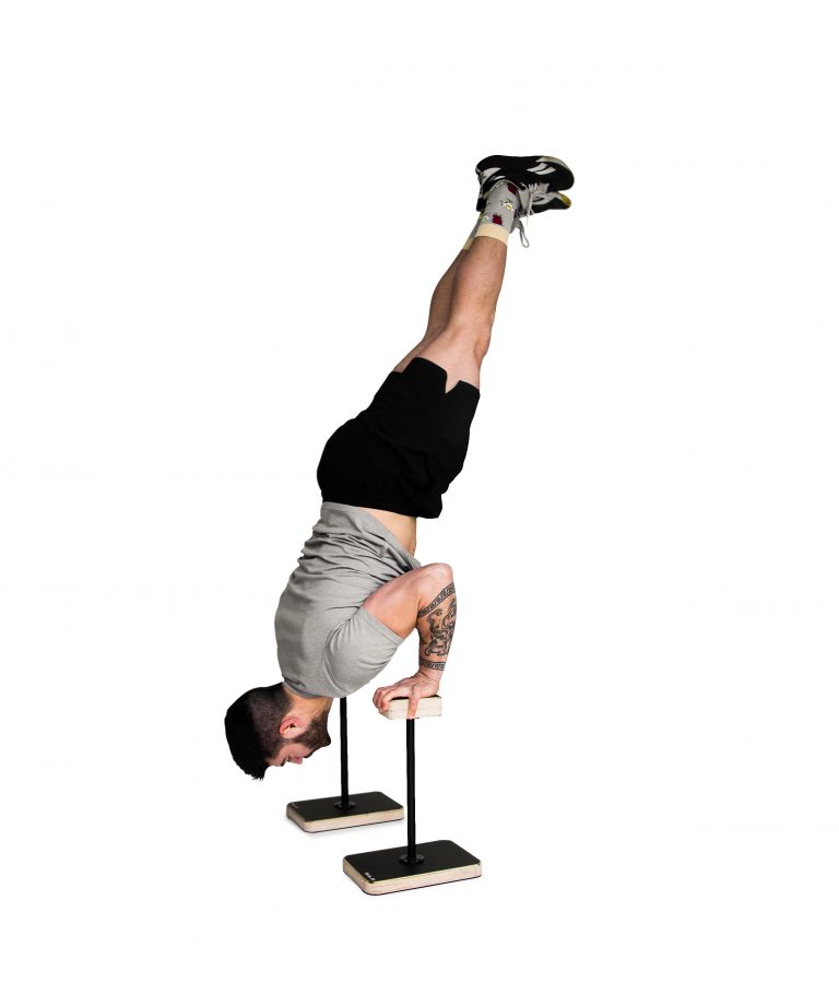 man performing a press to handstand on wooden forte fitness canes