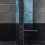 photo of a belt squat attachment in a gym resting on a wall
