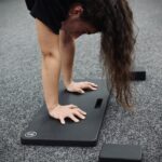 woman performing a handstand on a handstand board