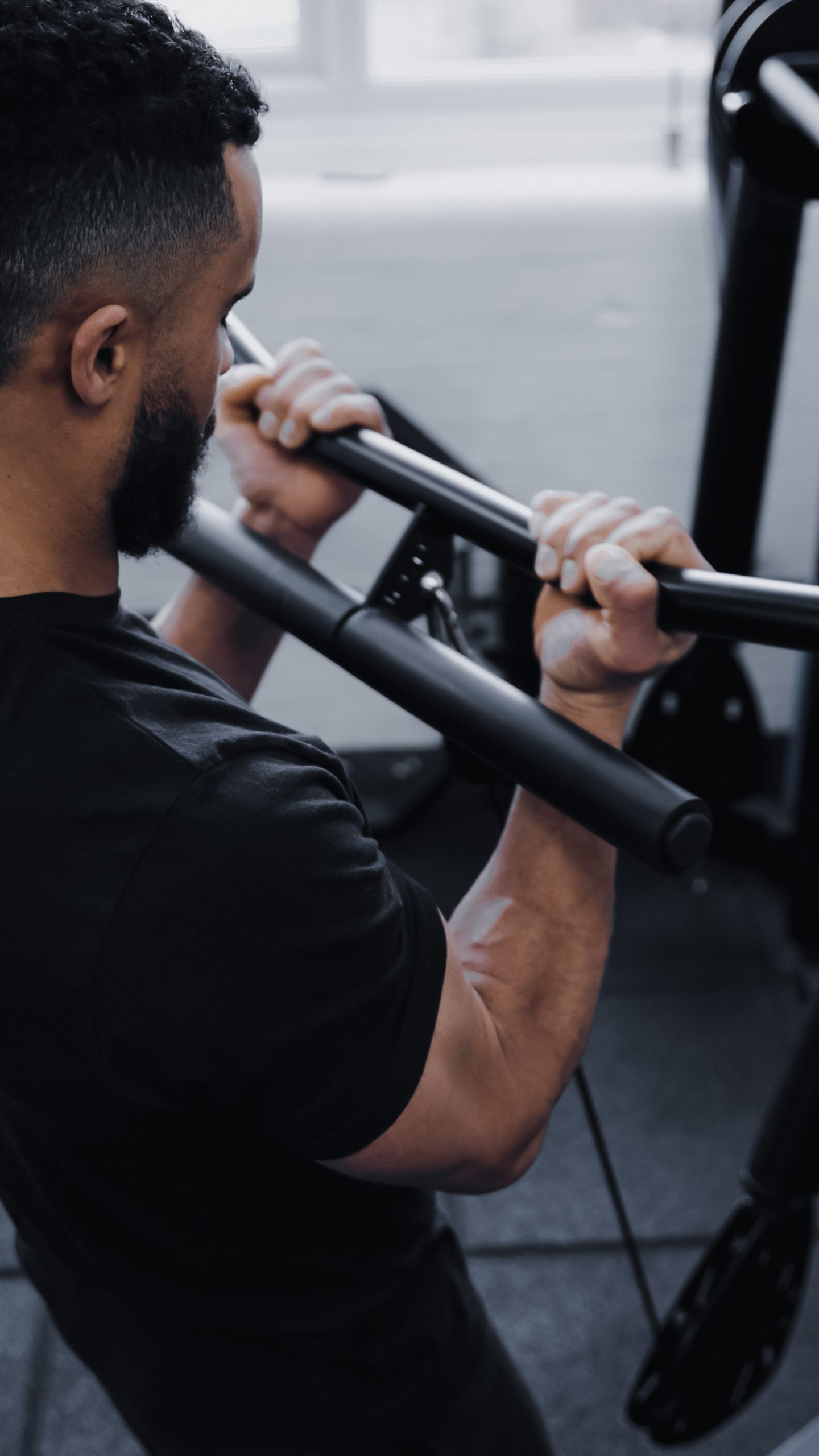 A man using the Forte Fitness black curl bar in a gym.