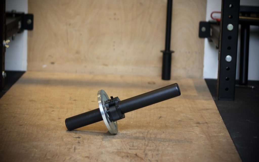 A black steel hammer extension placed on a wooden gym floor.