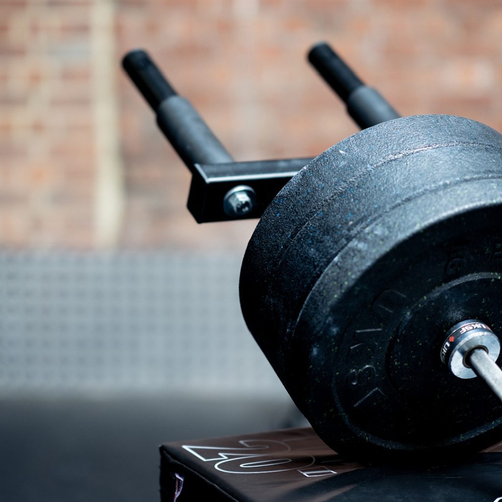 Hack squat attachment loaded with lifting plates and resting on a box