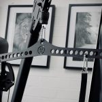 A Forte Fitness pulldown attachment in place in a gym. It is attached to the cable machine, with clips attached. The photo is in black and white.