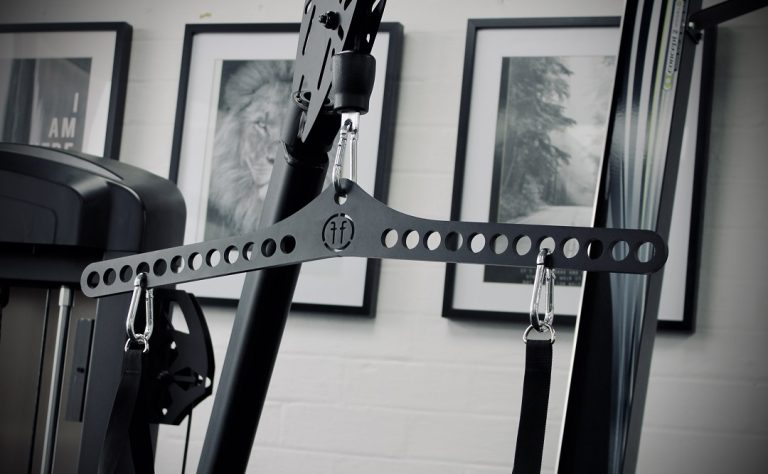 A Forte Fitness pulldown attachment in place in a gym. It is attached to the cable machine, with clips attached. The photo is in black and white.