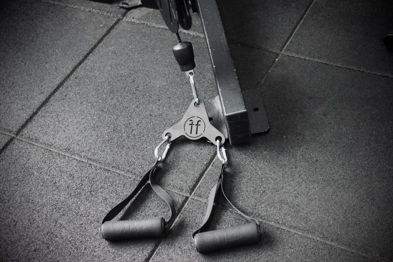 A Forte Fitness Adapt tool. The tool is attached to a cable machine, and is placed on the floor ready to be used. This picture is in black and white.