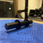 A Forte Fitness Axle Dumbbell bar without weights attached placed on a blue floor.