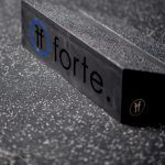 close up of a wooden slant board showing the blue and black forte fitness logo at the back