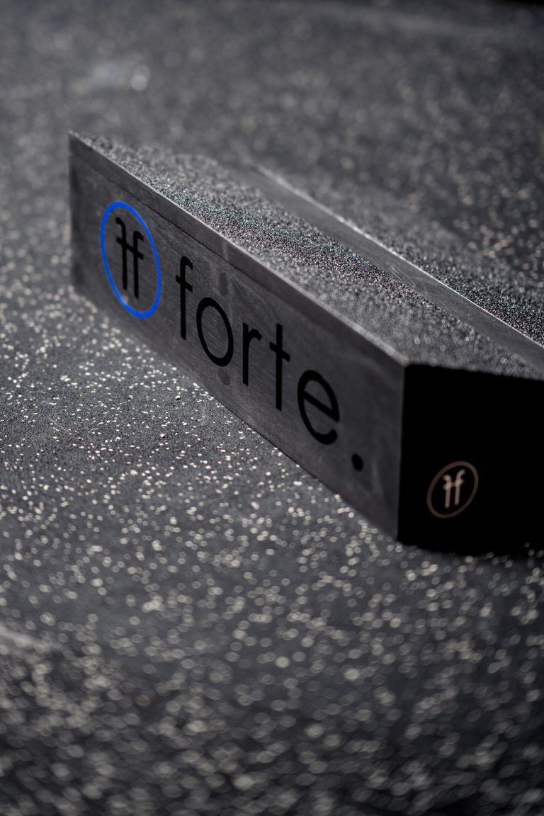 close up of a wooden slant board showing the blue and black forte fitness logo at the back