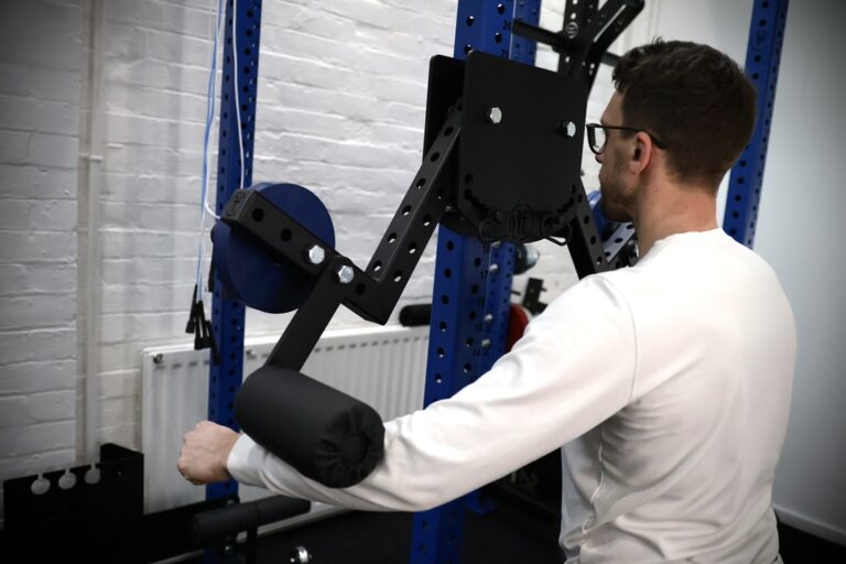man performing a lateral raise with a rack attachment