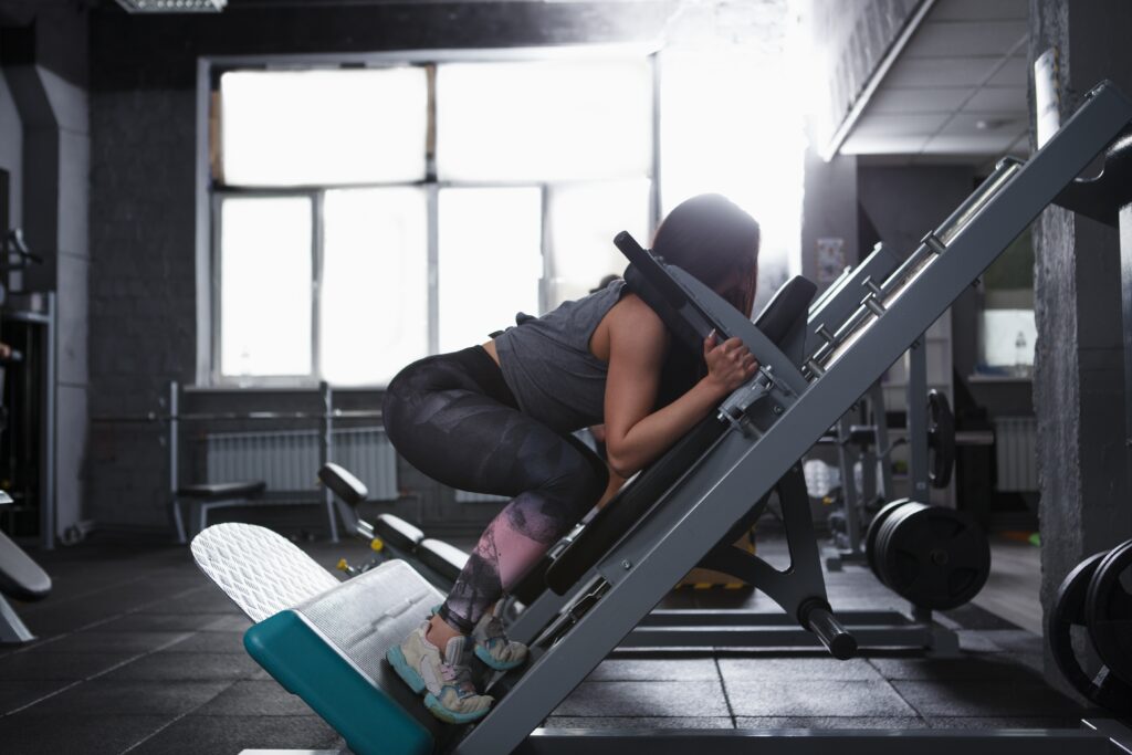 profile,shot,of,a,strong,athletic,woman,doing,squats, Hack Squats vs. Alternatives