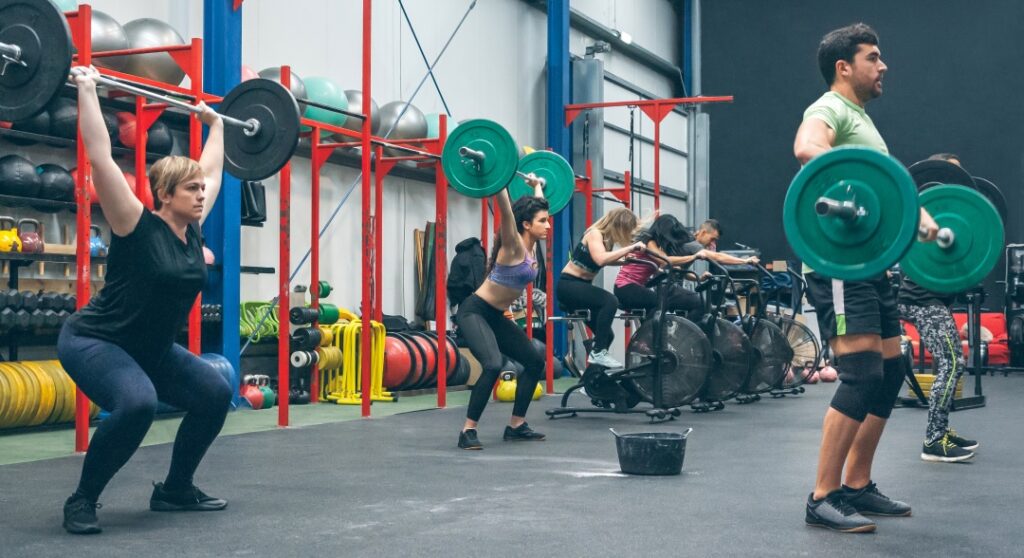 group of people practicing weightlifting in a crossfit gym