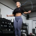 woman in a gym skipping with a blue skipping rope
