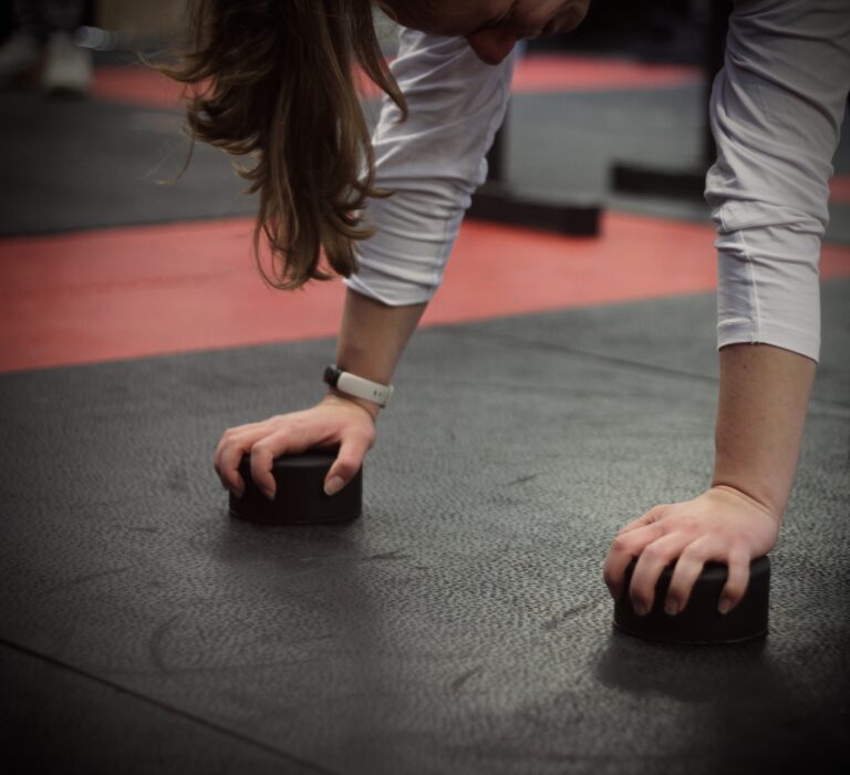 close up on woman's hands as she perform a handstand using some round black handstand blocks