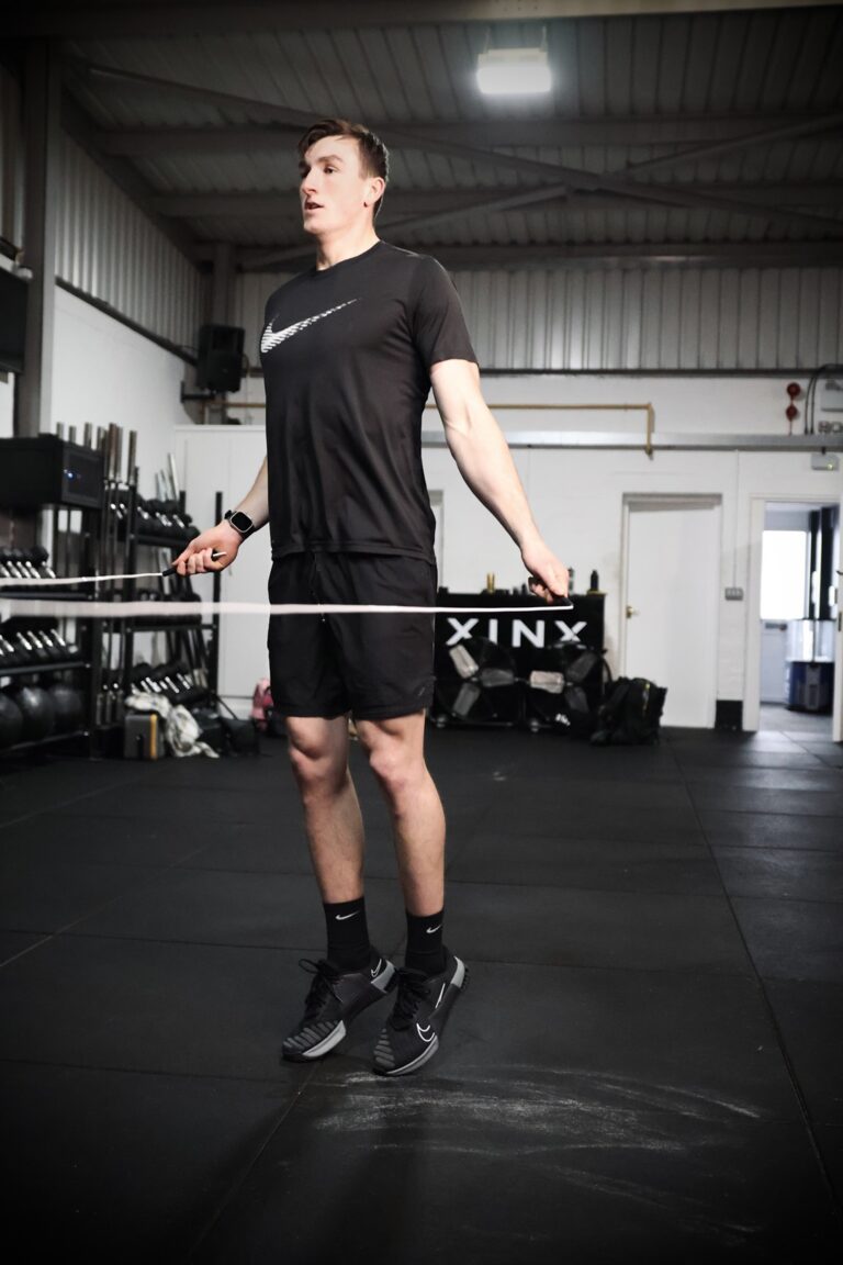 man in a gym skipping with a whiteskipping rope