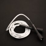 White vinyl skipping rope with Forte Fitness handles, on the floor