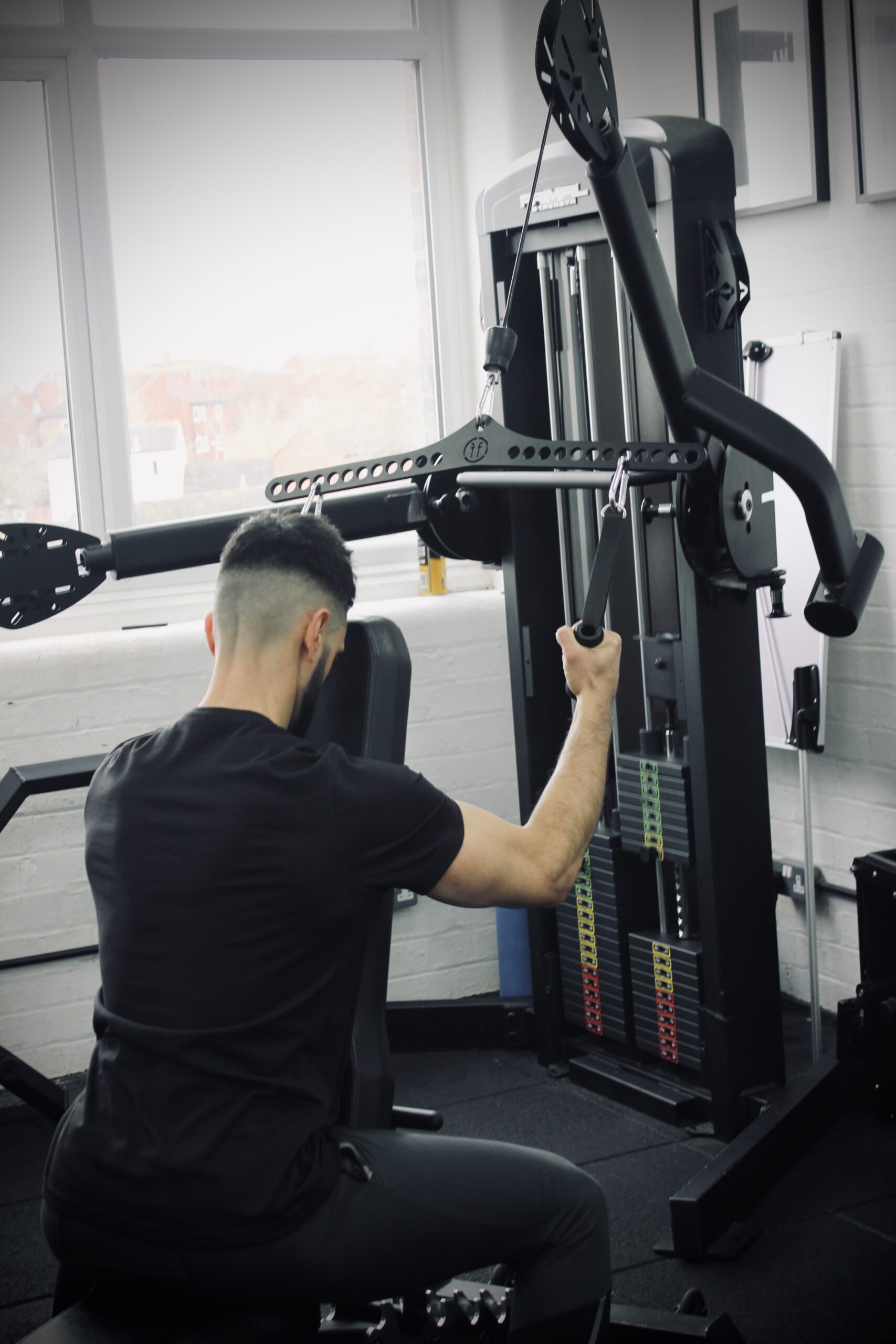 man doing a lat pulldown in a gym