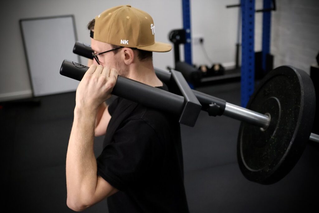 man performing a hack squat in a gym