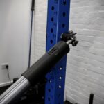 landmine attachment setup on a blue rack with barbell