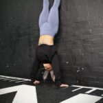 girl in a gym performing a handstand pushup