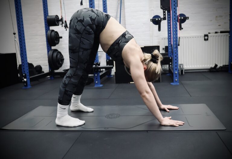 girl doing mobility recovery after a workout with downward dog position