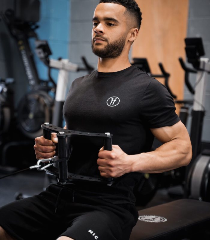 man in a gym performing a cable row exercise with a cable row attachment